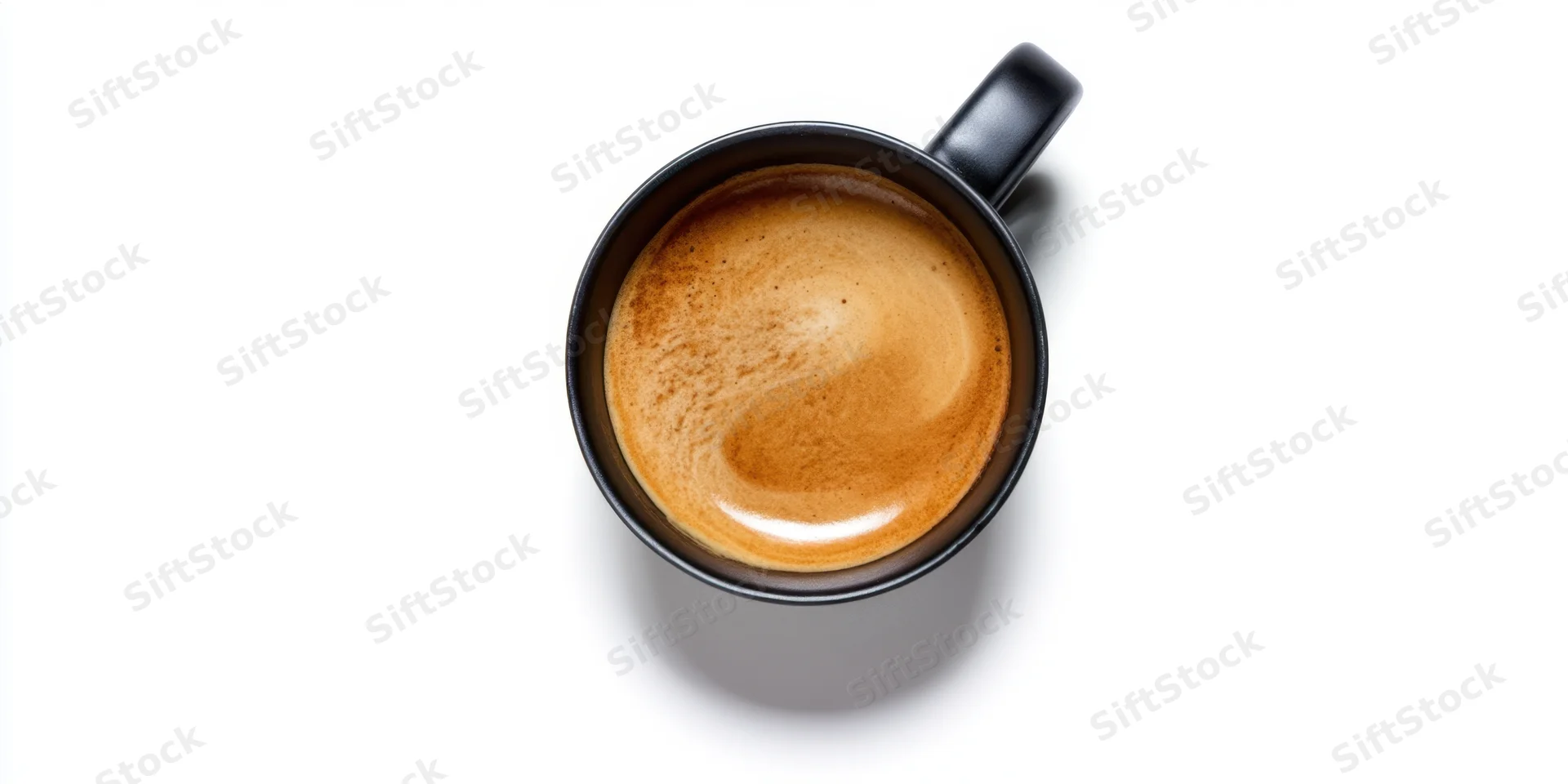 Black ceramic mug filled with coffee crema viewed from above on white background