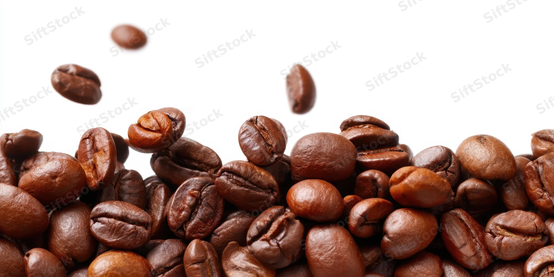 Roasted coffee beans piled along the bottom with some falling above on white background