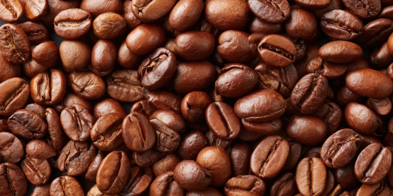 Roasted coffee beans densely scattered across the frame in closeup view
