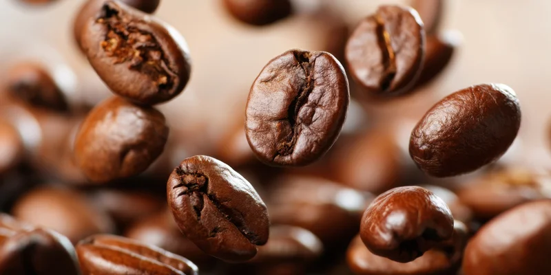 Roasted coffee beans floating in mid-air in close-up macro view