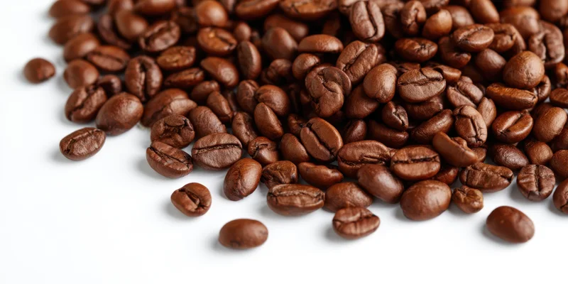 Roasted coffee beans scattered across a clean white background