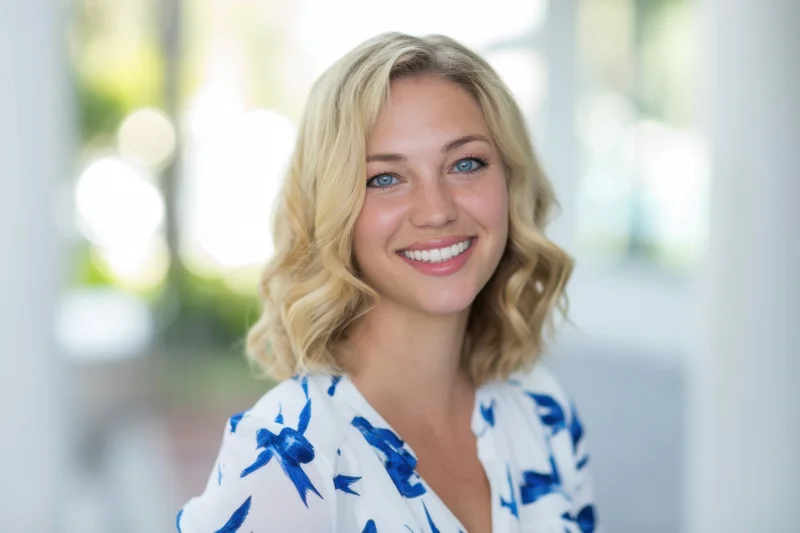 Cheerful blonde woman with shoulder-length wavy hair and blue