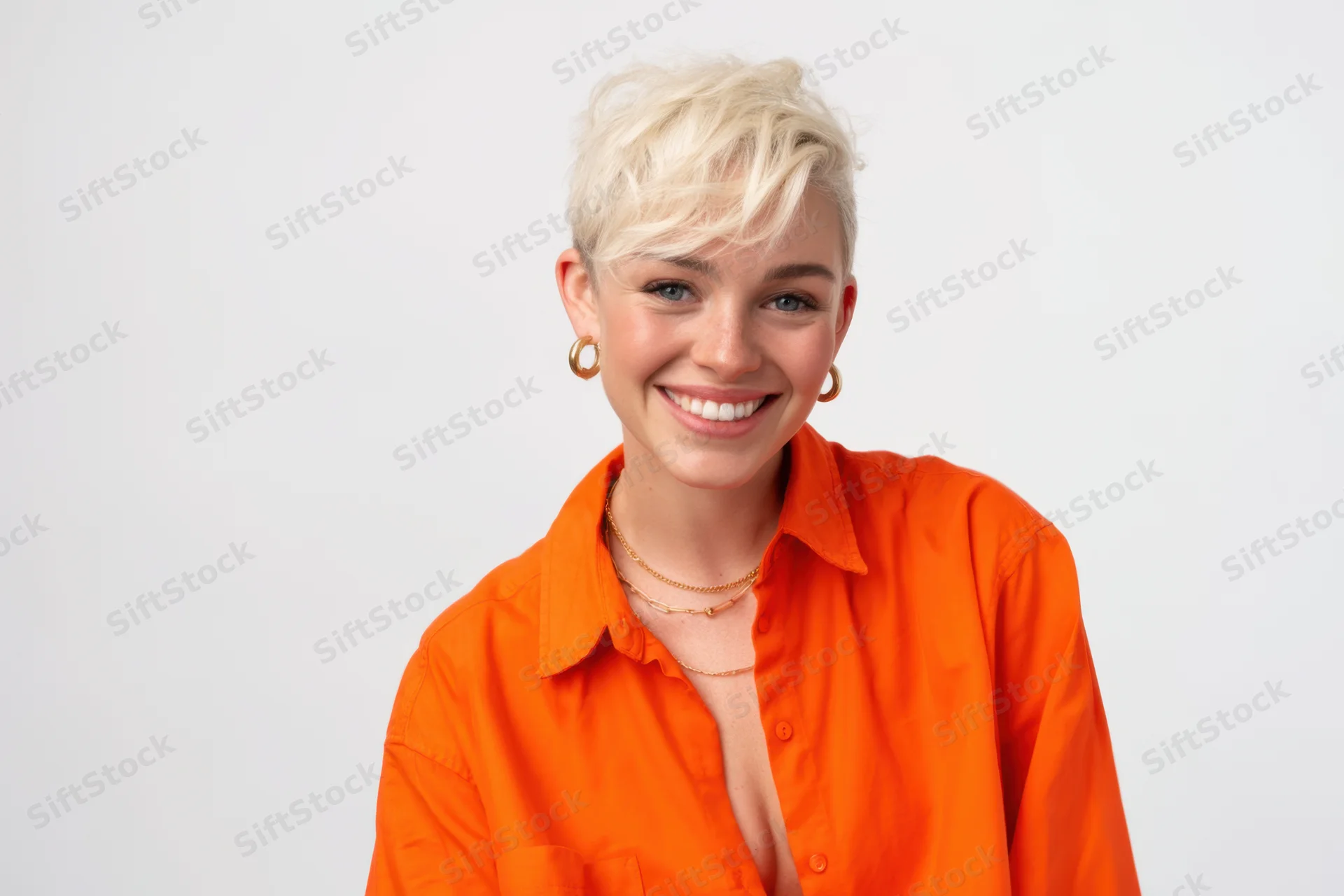 Smiling woman with short platinum blonde hair wearing orange shirt in studio portrait