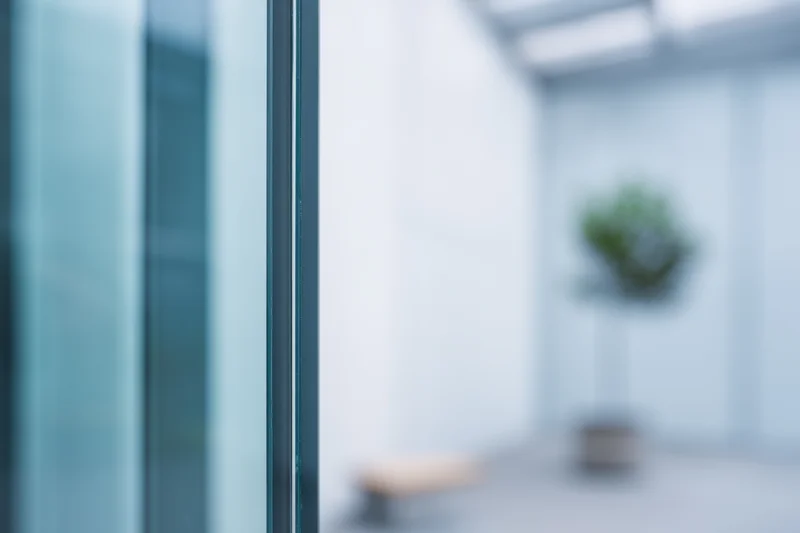 Close-up of a glass window pane with reflections in a modern office interior