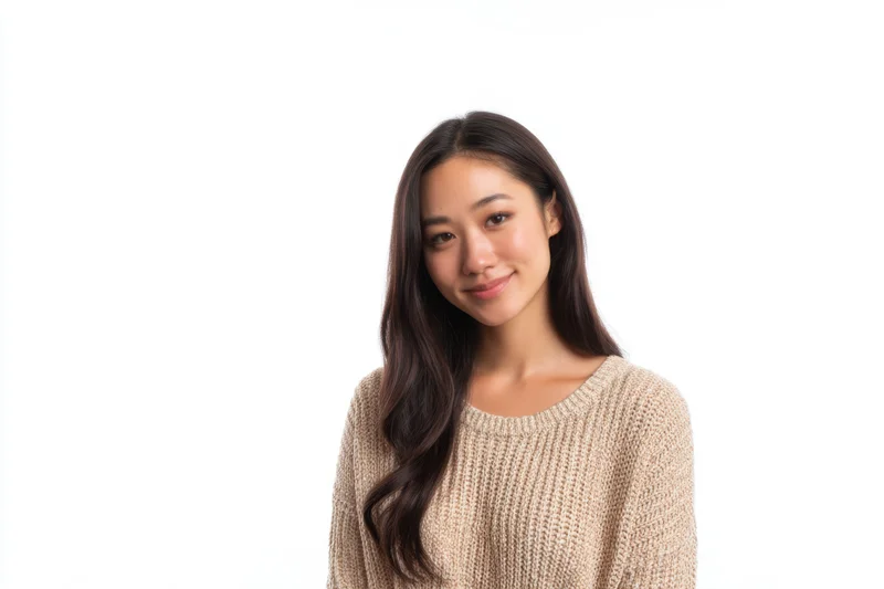Young asian woman smiling in a beige knit sweater against white background