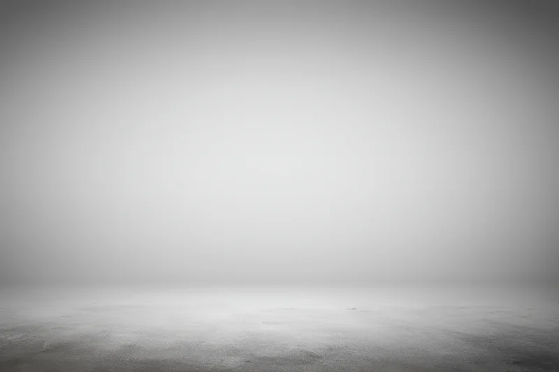 Smooth neutral gray studio backdrop with soft gradient and empty floor space