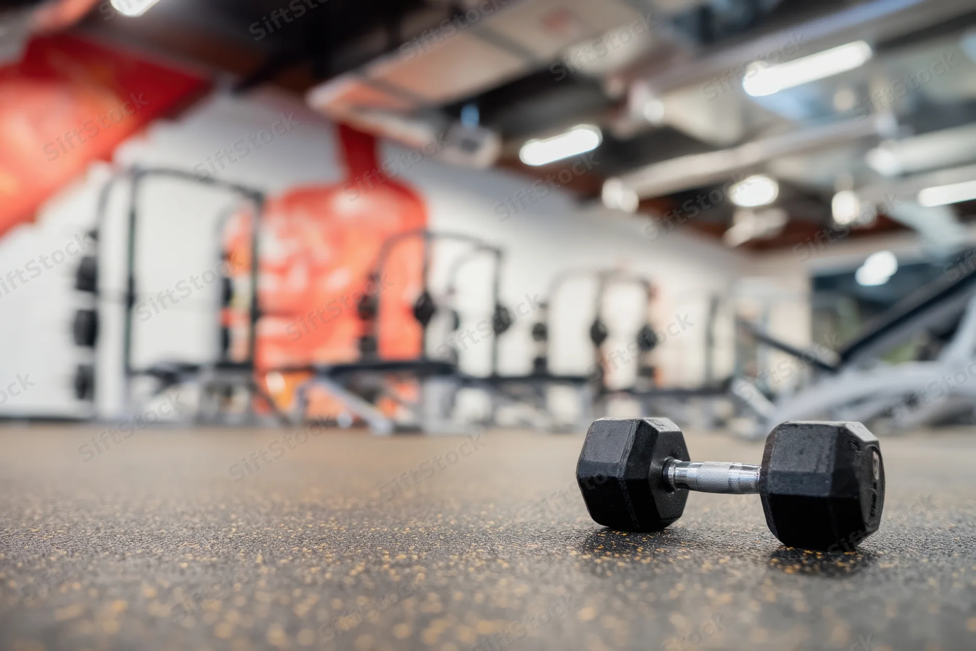 Dumbbell resting on rubber floor in gym interior