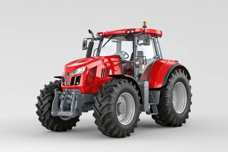 Red agricultural tractor parked stationary in studio setting