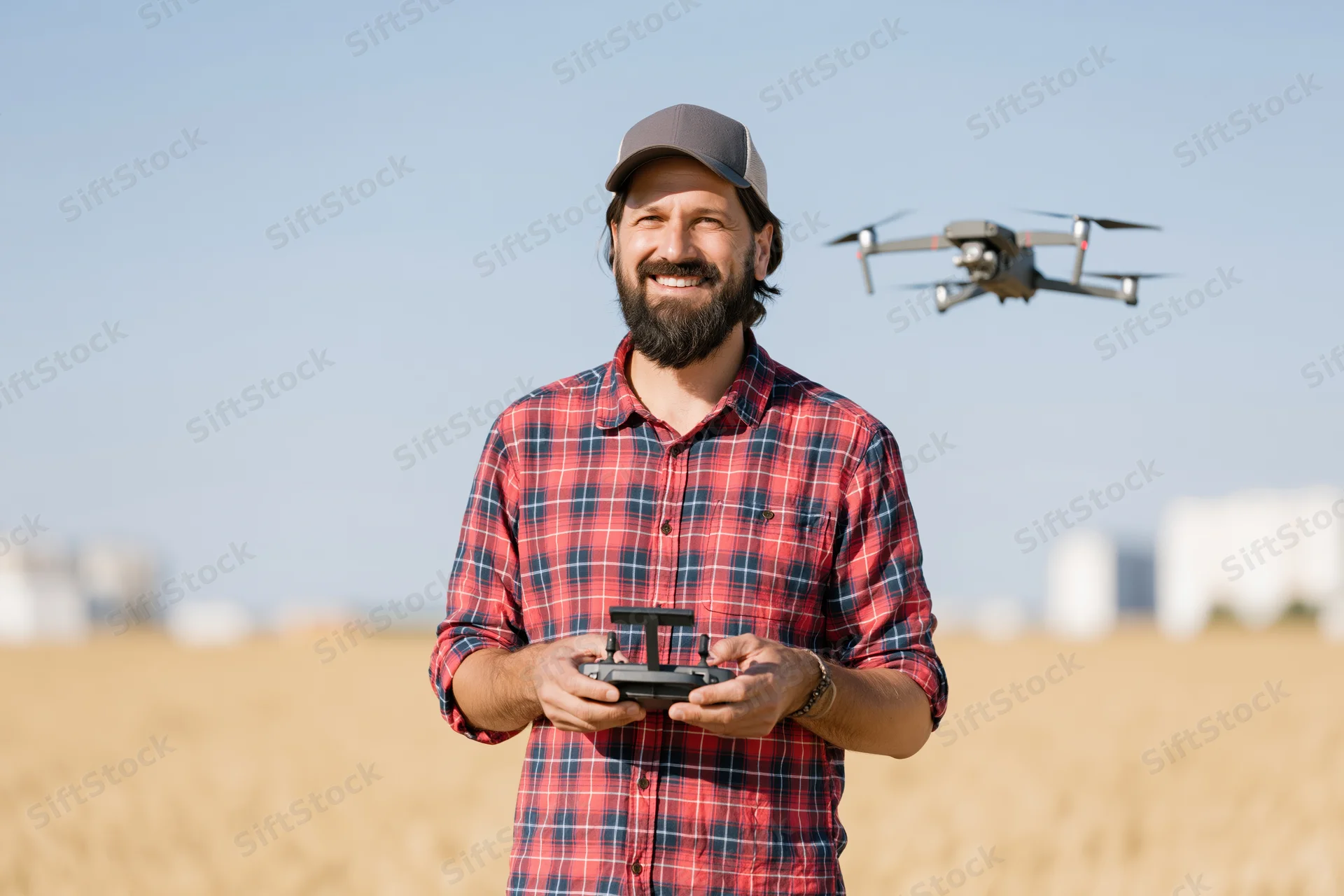 Man operating drone with remote control in a wheat field