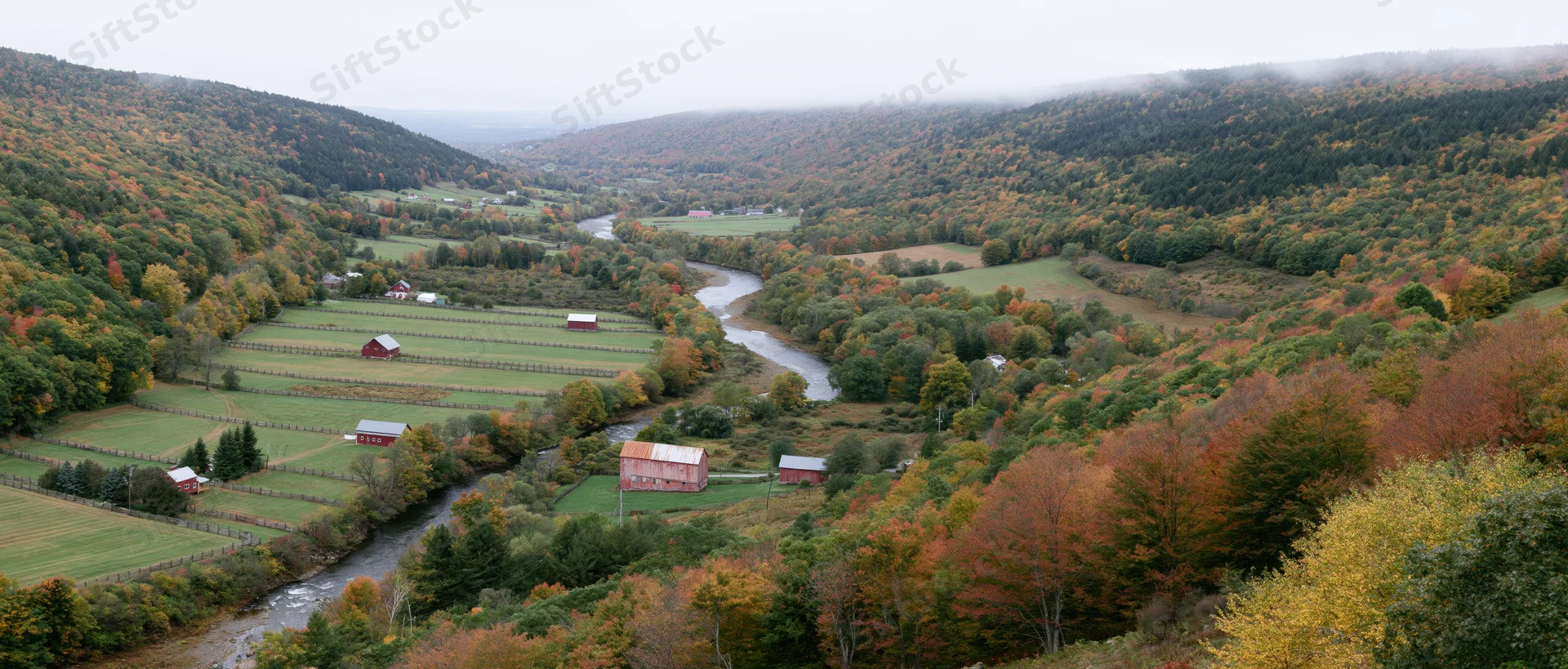 Winding river through autumn valley with farms and forests in new england