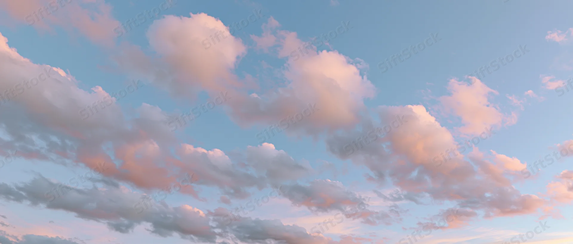 Soft cumulus clouds drifting across a blue sky at twilight