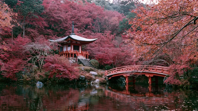 Small red japanese pagoda and arched bridge on wooded island surrounded by autumn foliage reflecting in calm water