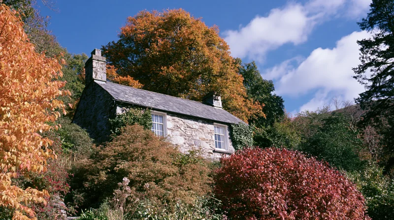 Stone cottage nestled among autumn foliage in a rural garden setting