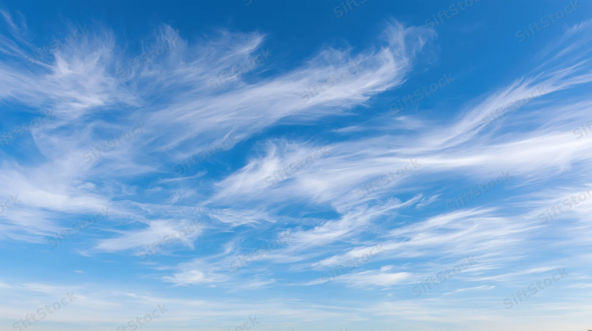 Wide panoramic view of open daytime sky filled with wispy cirrus clouds