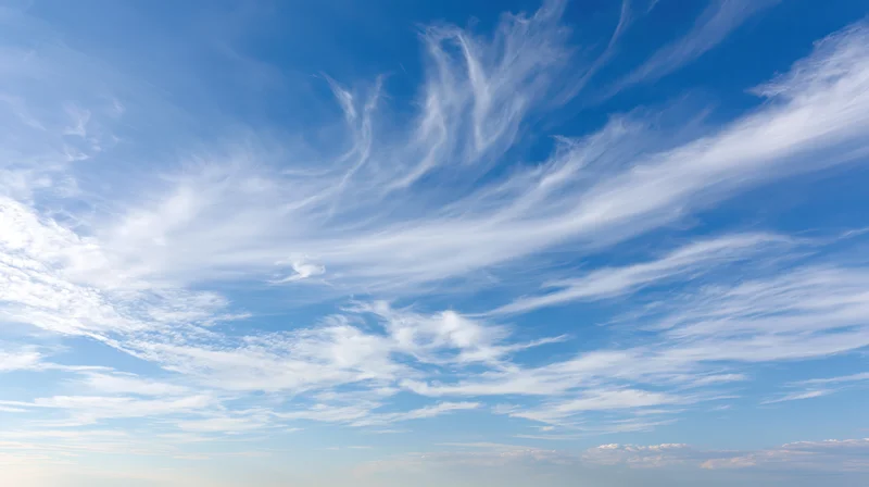 Wide panoramic view of open daytime sky filled with wispy cirrus clouds