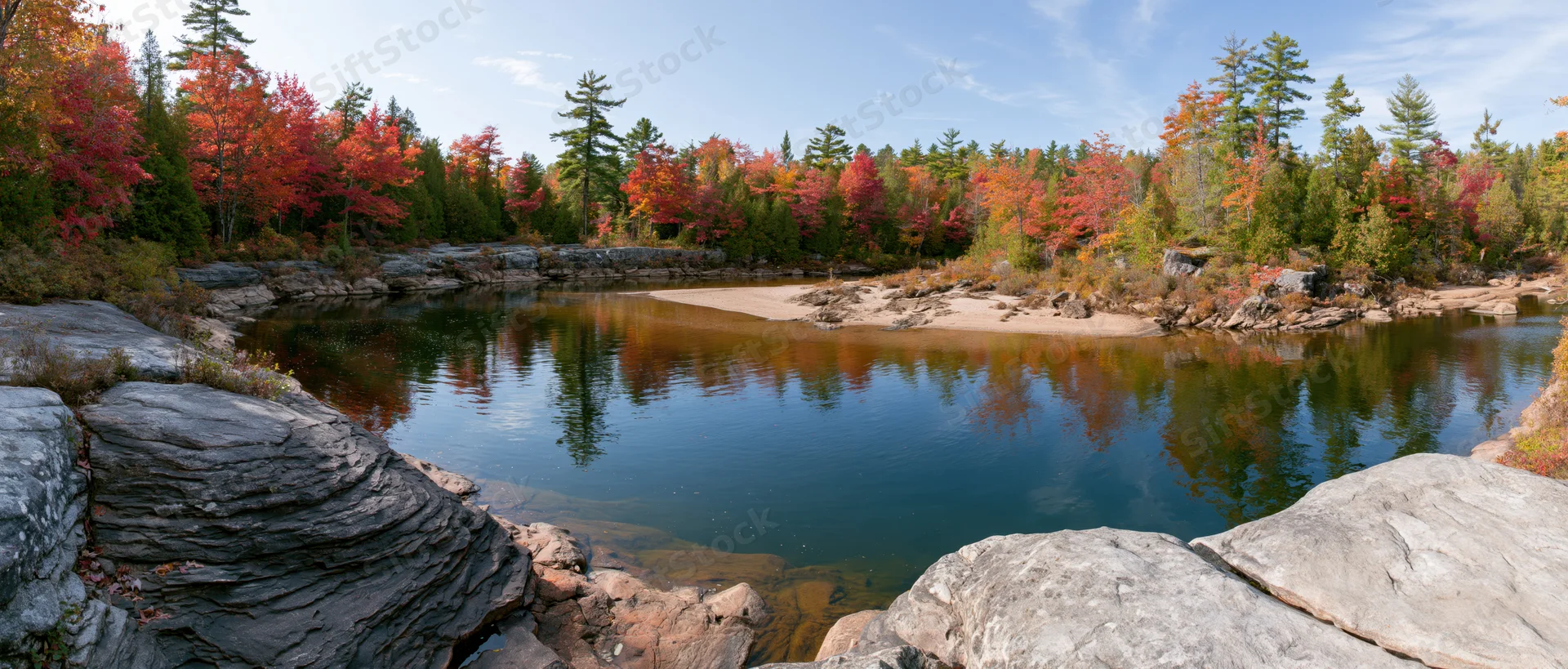 Calm river bend surrounded by autumn forest reflecting in still water