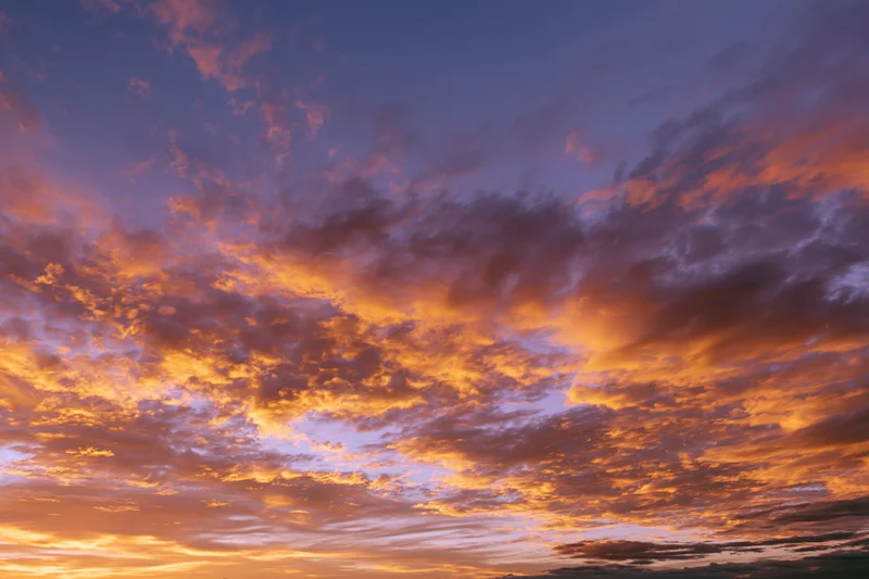 Dramatic sunset sky filled with orange and purple clouds, no horizon visible