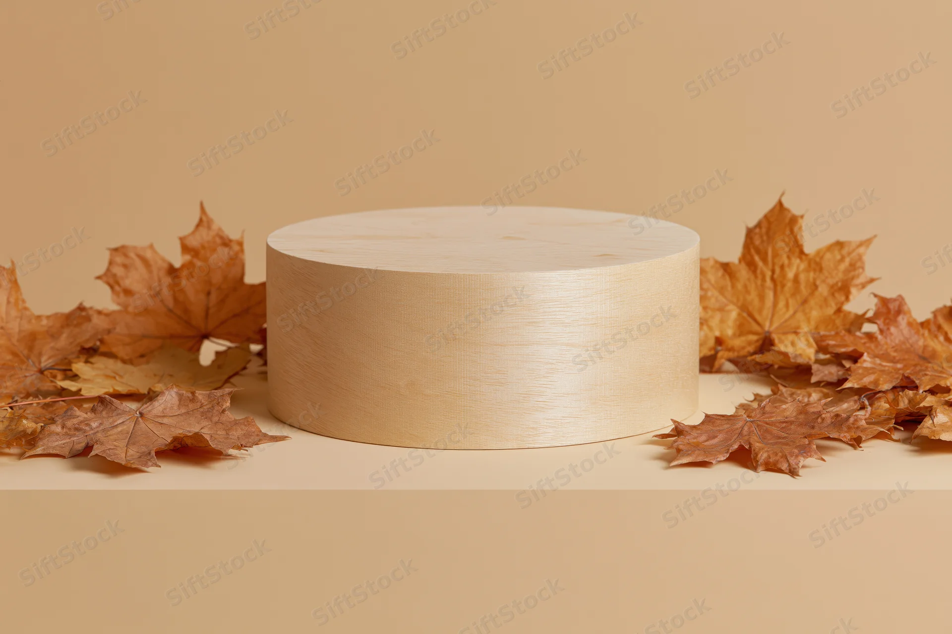 Wooden cylindrical podium on a flat surface surrounded by dried maple leaves