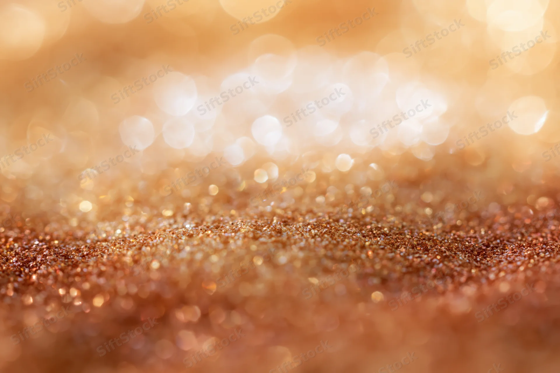 Golden glitter surface with soft bokeh lights in background