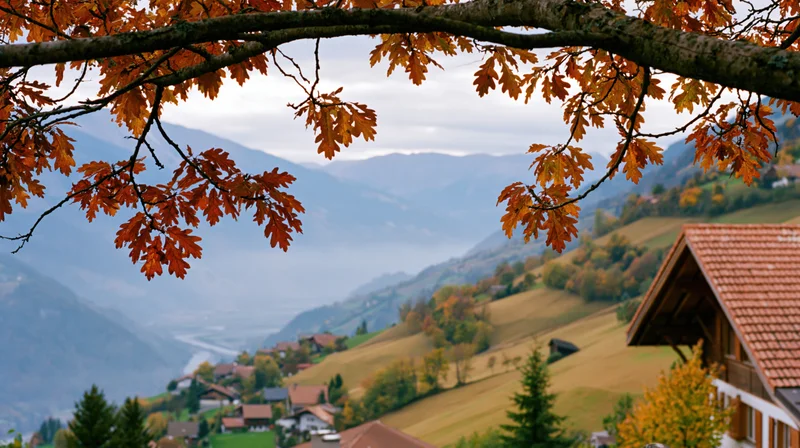 Autumnal oak branches framing a mountain village in the alpine valley