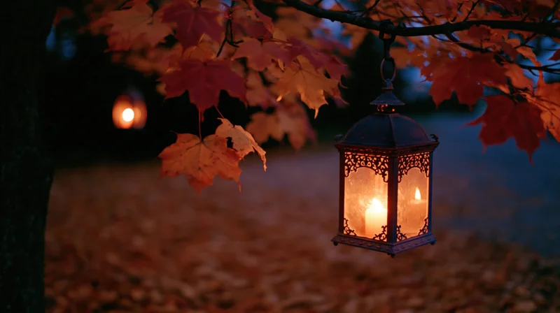 Ornate metal lantern glowing with candlelight hanging from a maple tree branch in an autumn forest at twilight