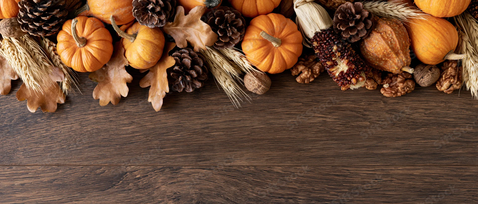 Autumn harvest arrangement of small pumpkins gourds and dried elements on wooden table with copyspace