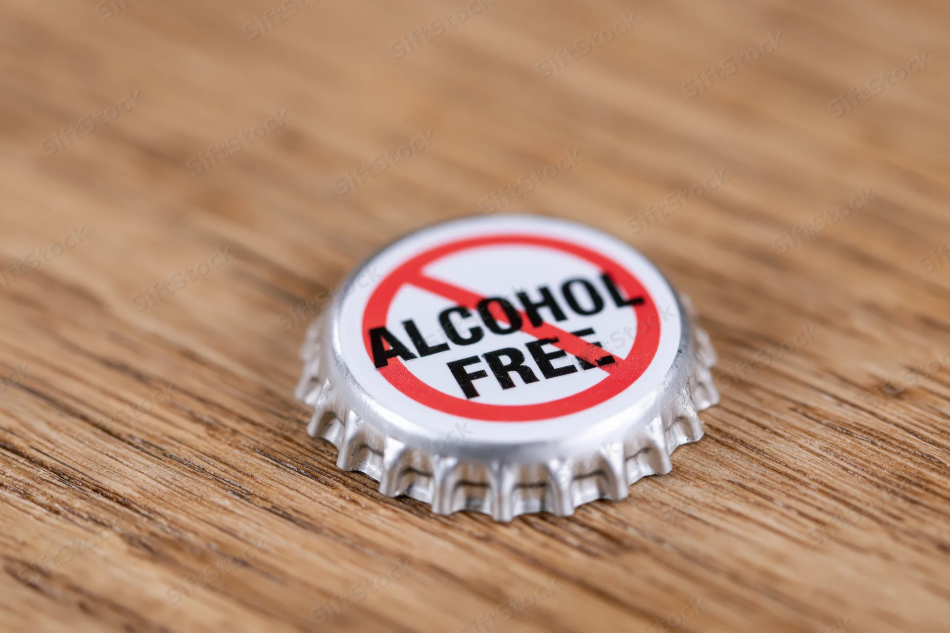 Metal bottle cap with alcohol free prohibition symbol on wooden surface