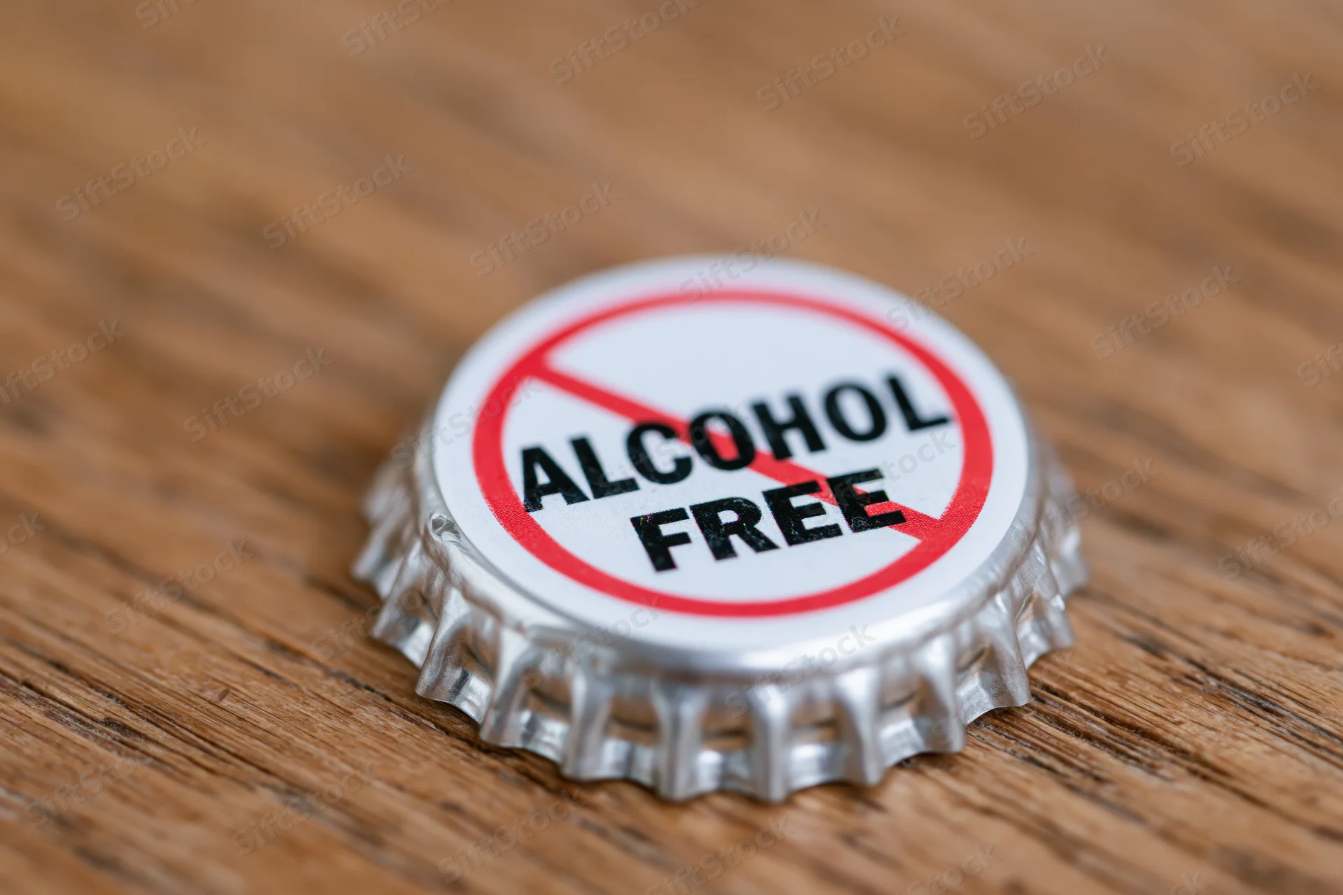 Metal bottle cap with alcohol free prohibition symbol on wooden surface