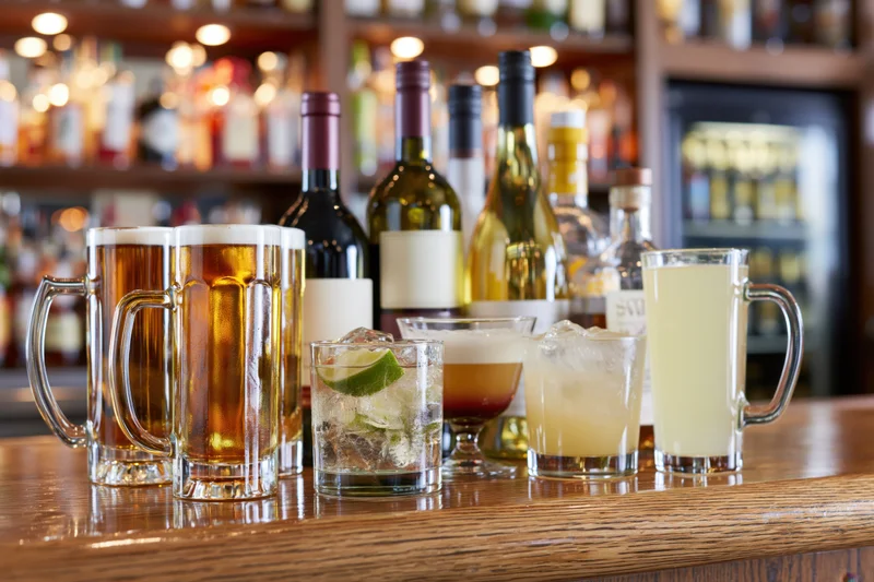 Assorted bar drinks arranged on a polished wooden bar counter