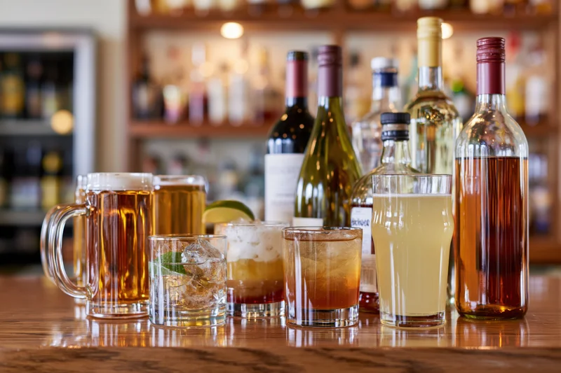 Assorted bar drinks arranged on a polished wooden bar counter