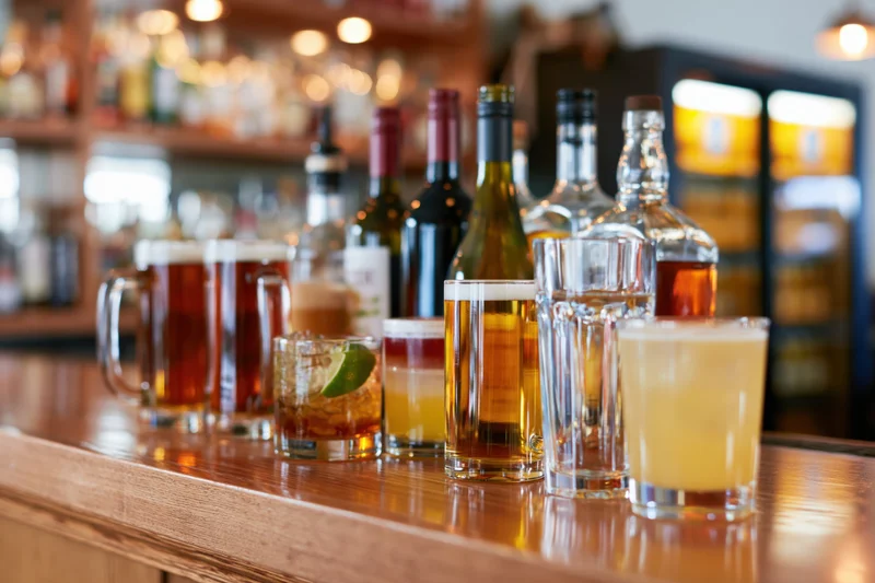 Assorted bar drinks arranged on a polished wooden bar counter