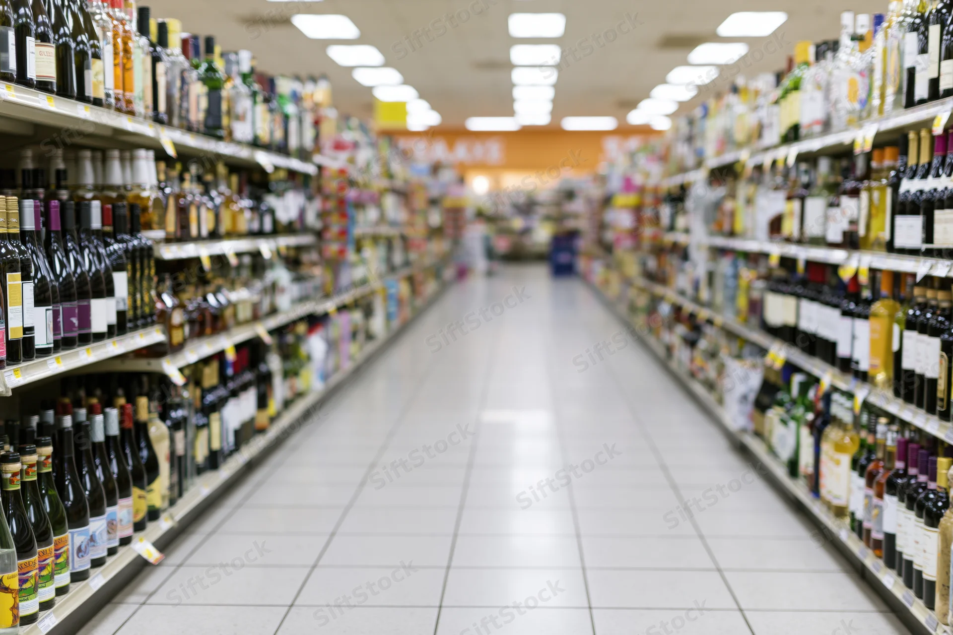 Empty liquor store aisle with shelves of bottles stretching into the distance