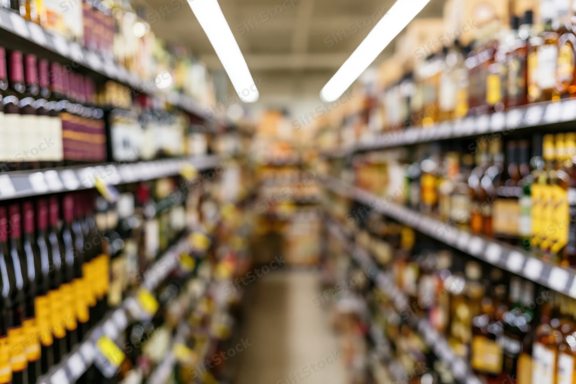 Liquor store aisle with tall shelves filled with bottles stretching into the distance