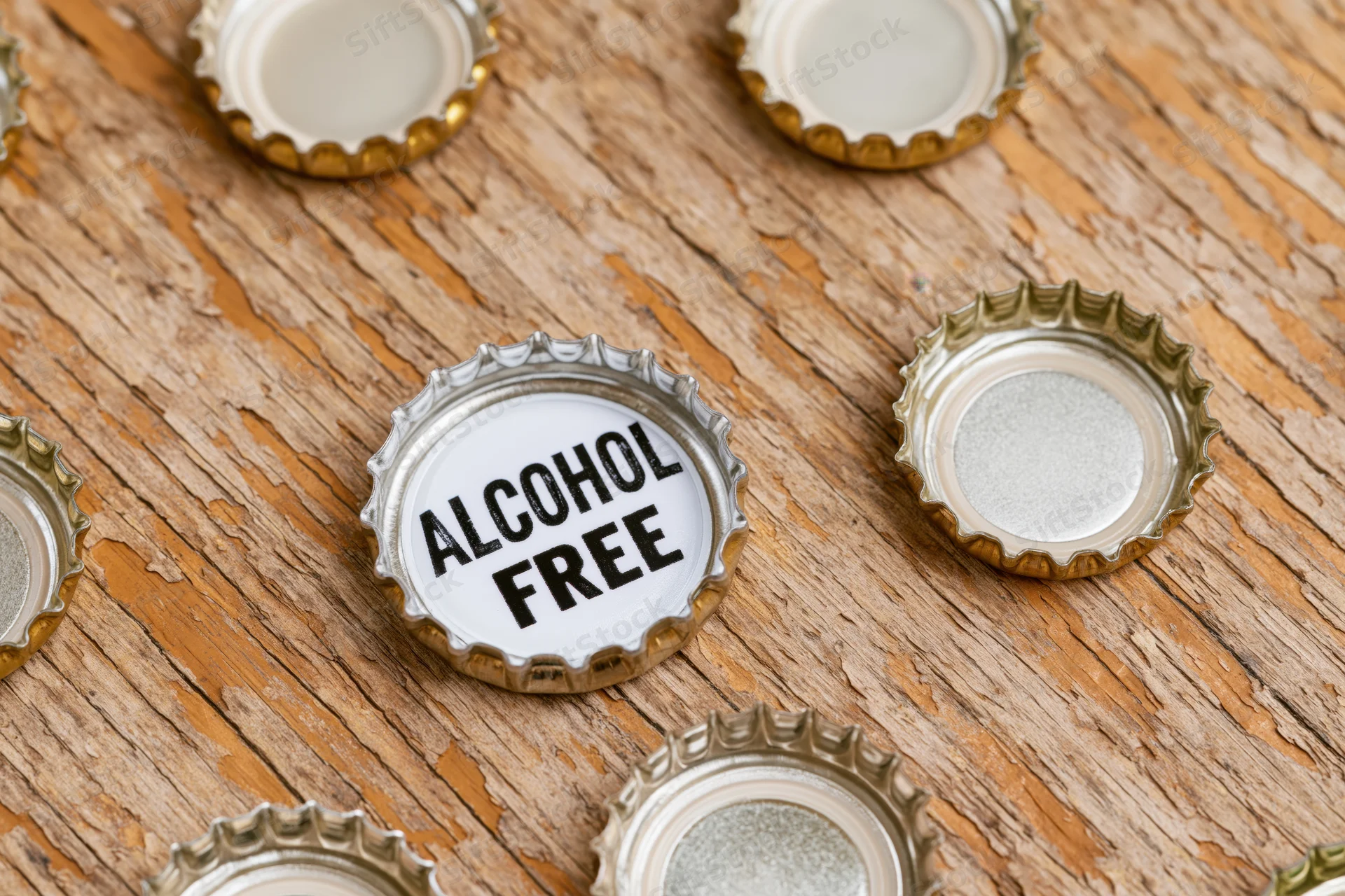 Metal bottle cap with alcohol free text on wooden surface