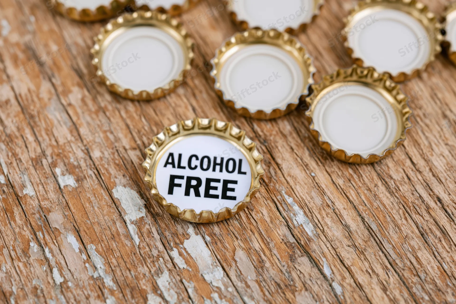 Bottle caps with alcohol free label on wooden surface