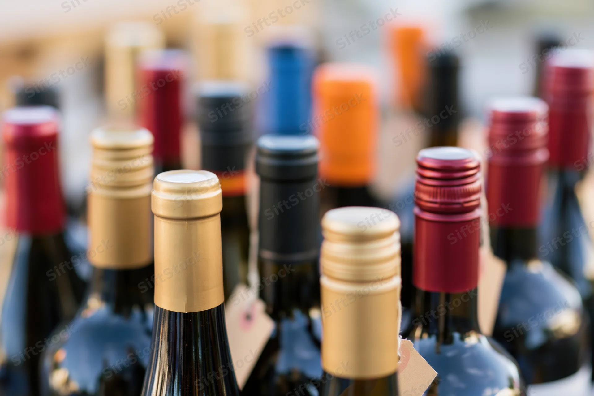 Closeup of assorted wine and liquor bottle tops arranged in rows on display