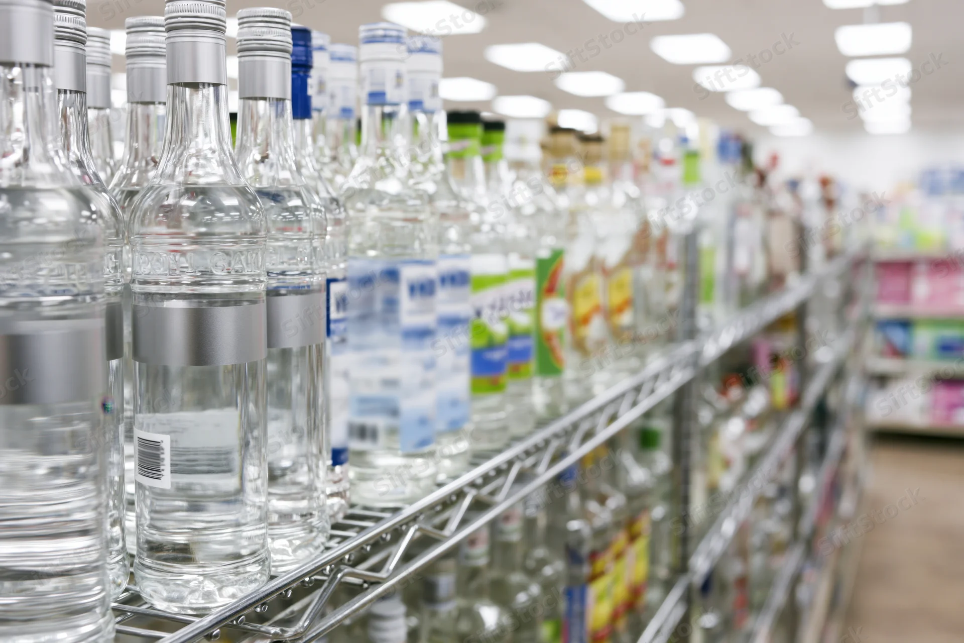 Rows of vodka and spirits bottles on metal shelves in a retail store aisle