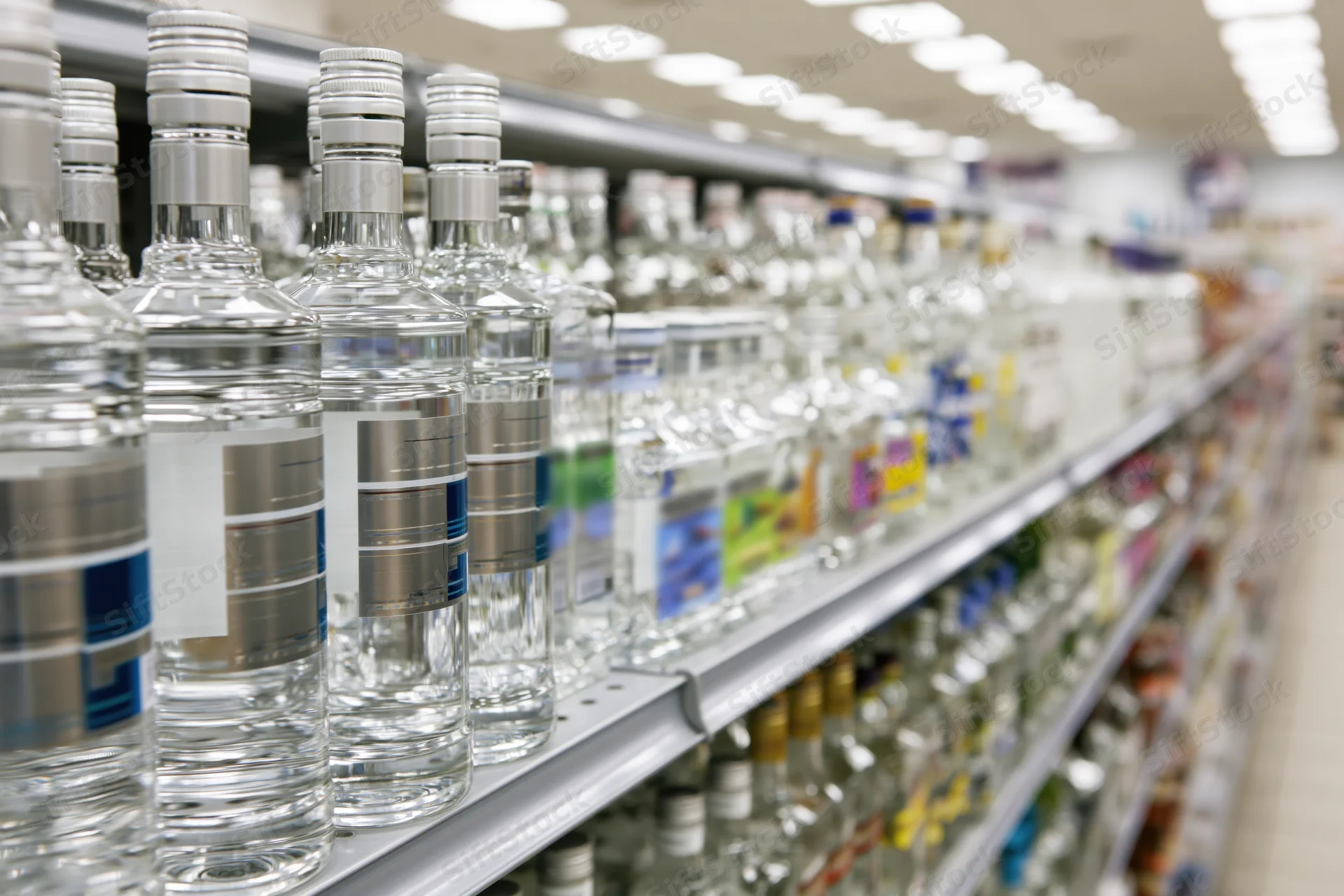 Rows of vodka and spirits bottles on metal shelves in a retail store aisle
