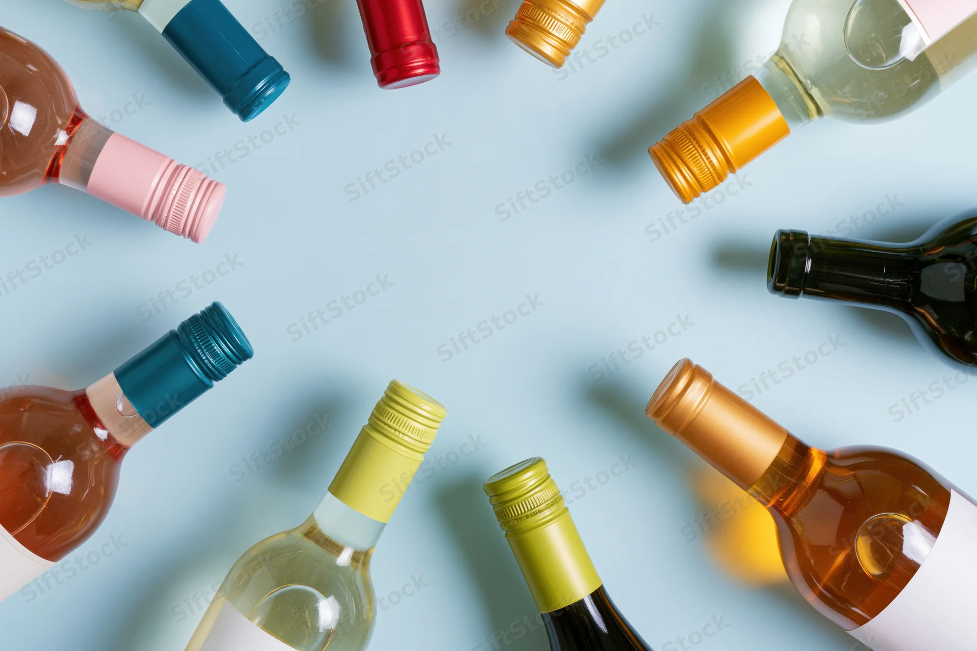 Wine bottles arranged neck-inward around frame edges on blue background with copyspace