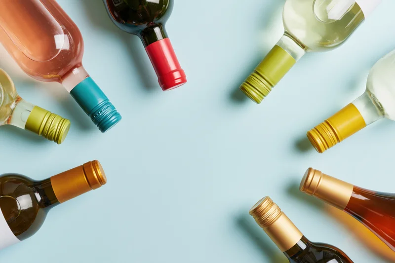 Wine bottles arranged neck-inward around frame edges on light blue background