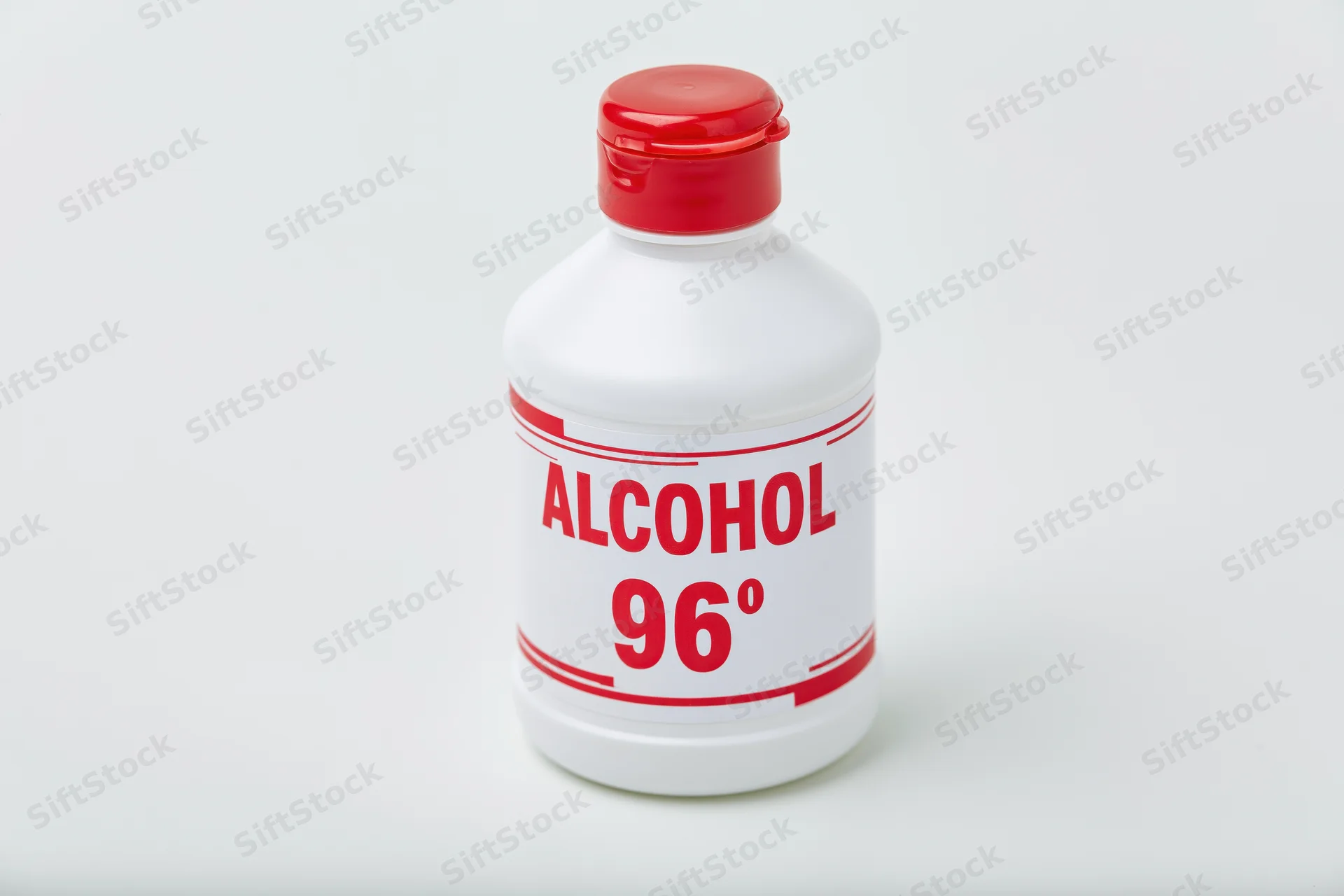 White plastic bottle of 96 degree alcohol with red cap and label on plain background