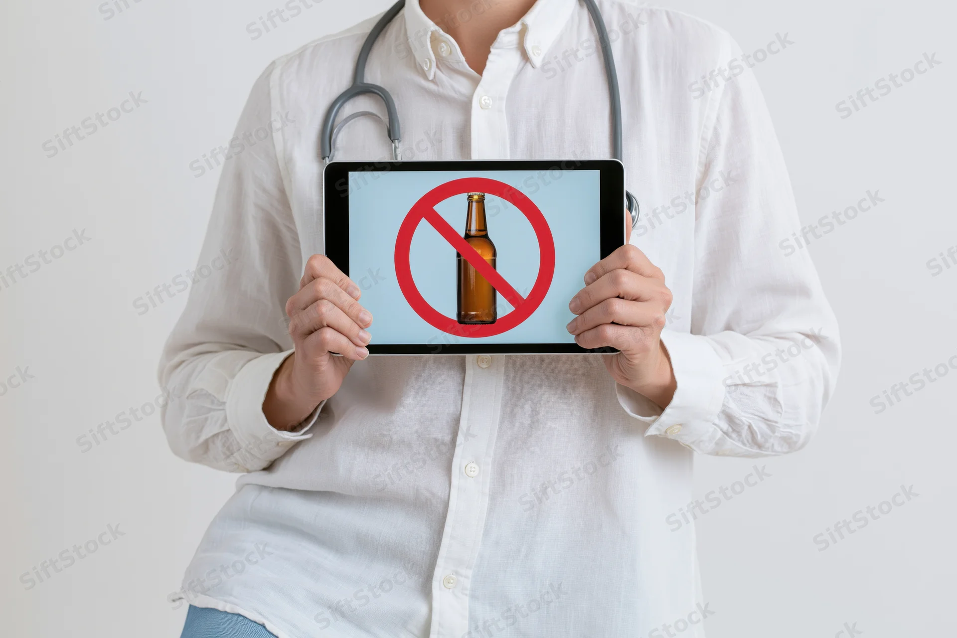 Doctor holding tablet with no alcohol symbol on screen