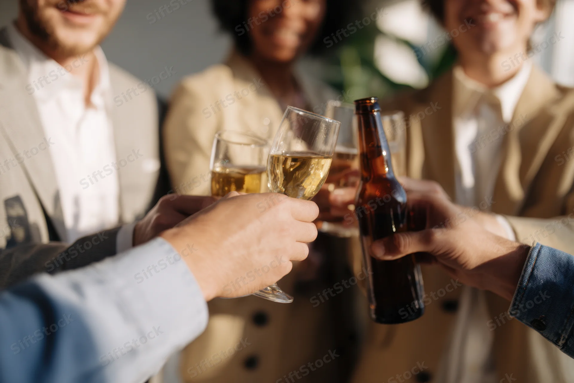 Group toasting with beer and wine glasses in a casual outdoor gathering