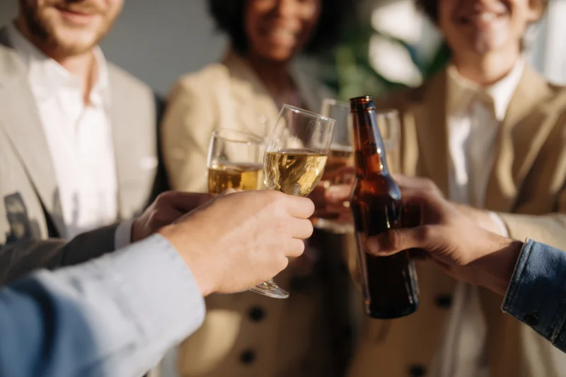 Group toasting with beer and wine glasses in a casual outdoor gathering