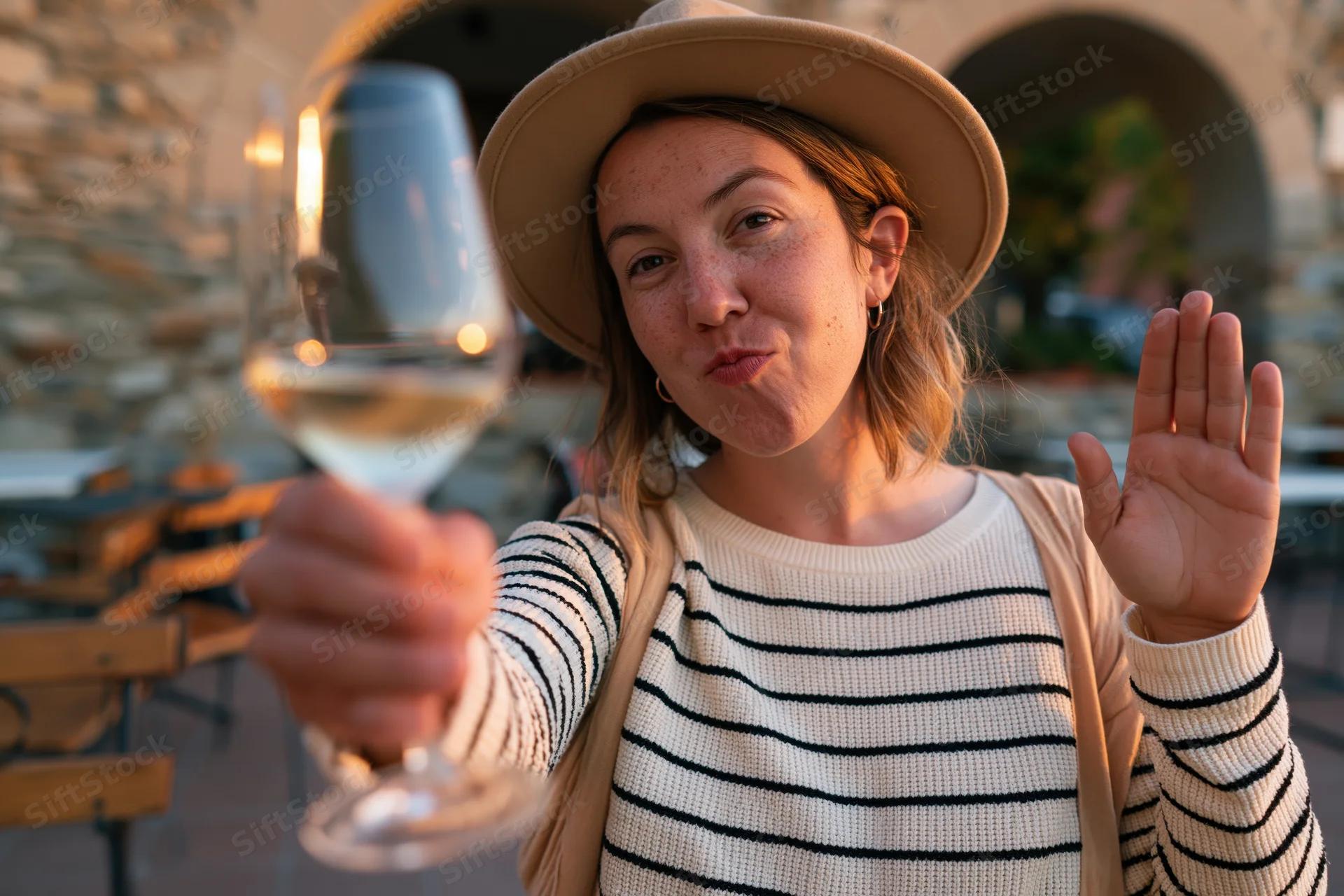 Woman toasting with wine glass at outdoor cafe patio