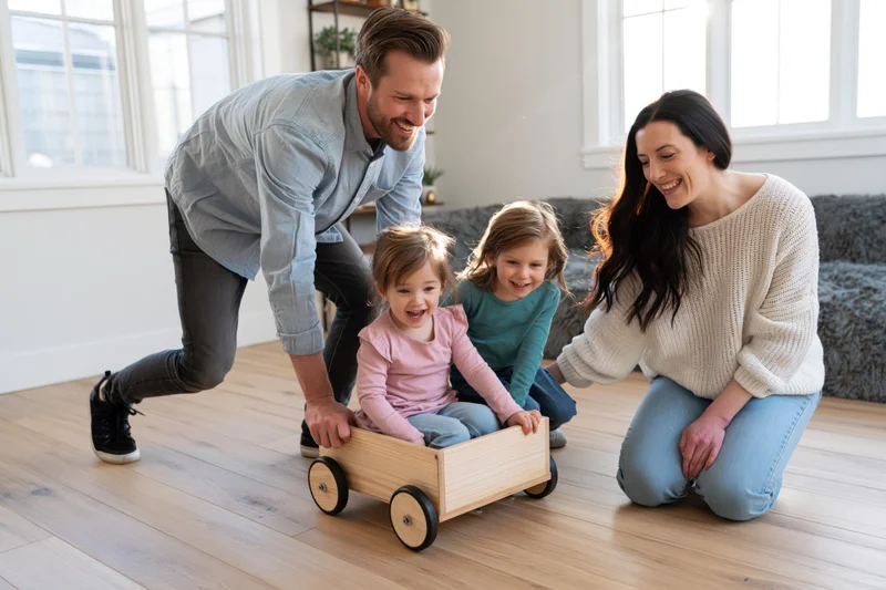 Family playing with wooden wagon indoors in bright living room