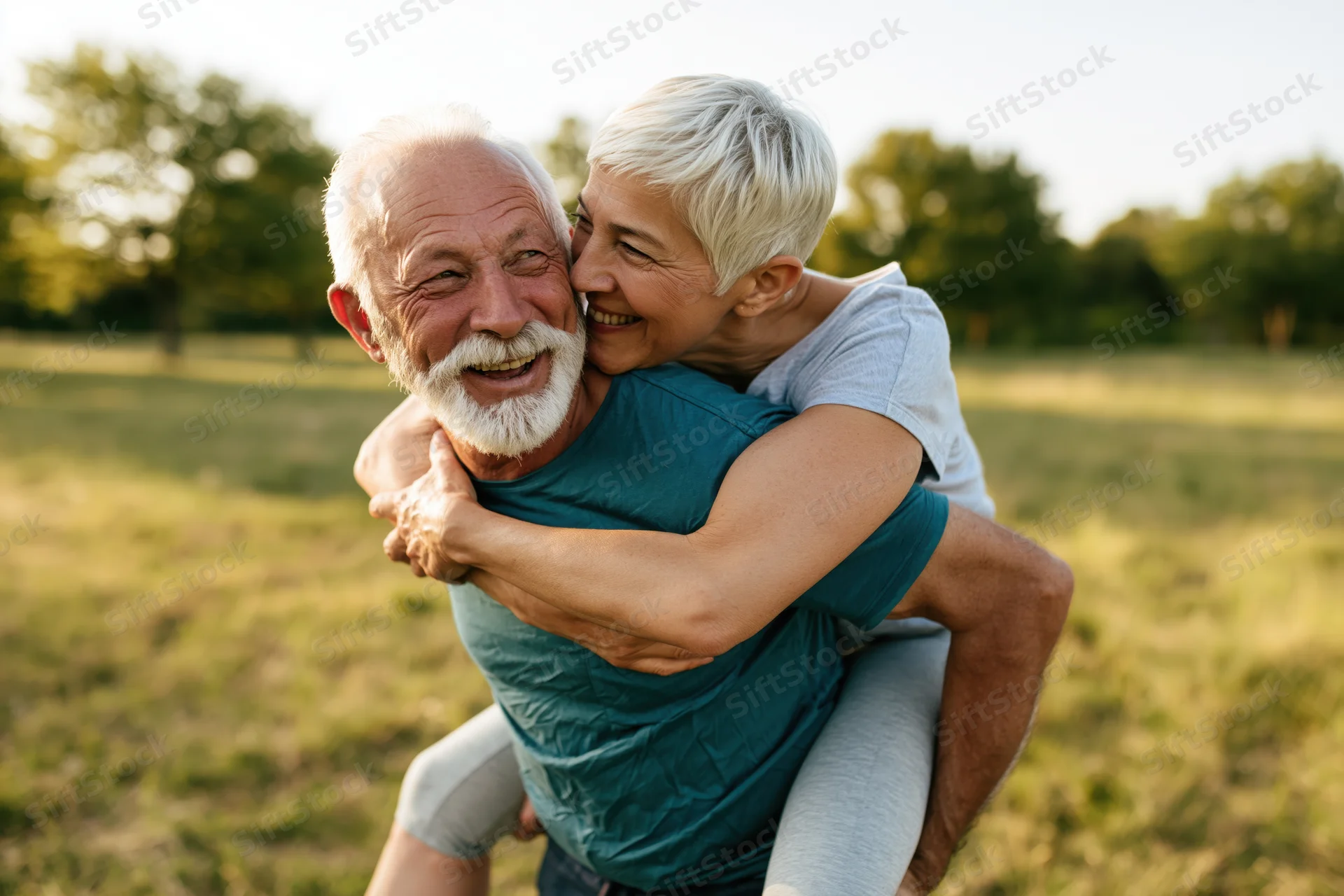 Senior couple sharing a piggyback hug in a sunlit grassy field
