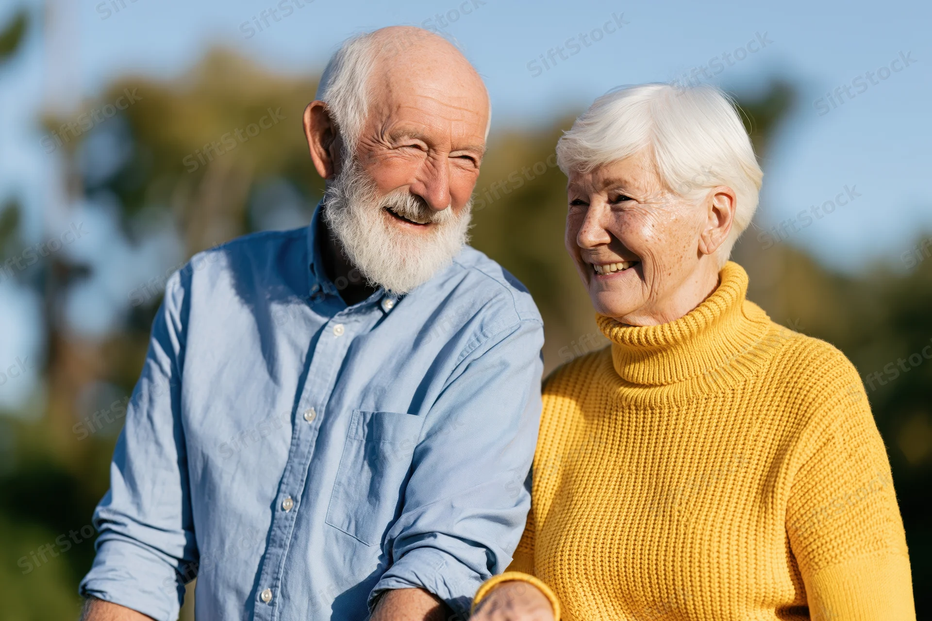 Elderly couple smiling together outdoors in late afternoon sunlight