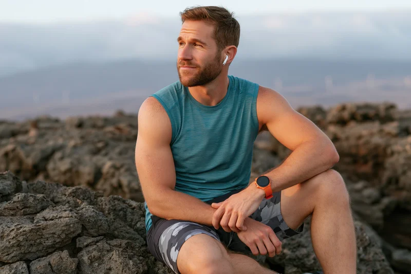 Man resting on volcanic rock formation during sunset outdoors