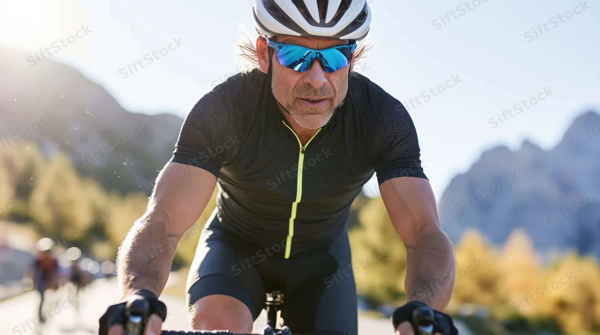 Senior man riding a road bike on a mountain trail in daylight
